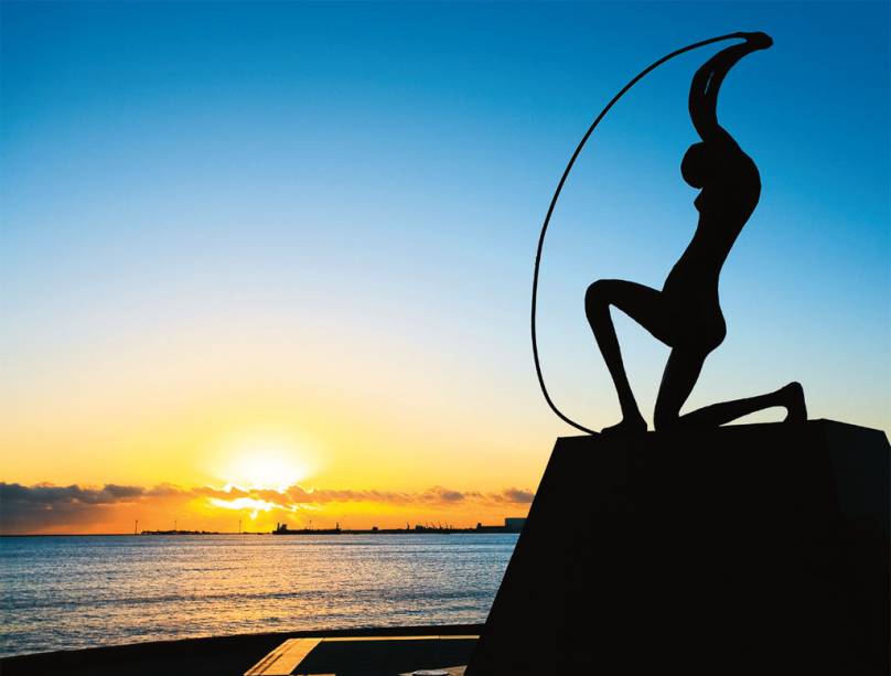 O sol atrás da estátua de Iracema em Fortaleza