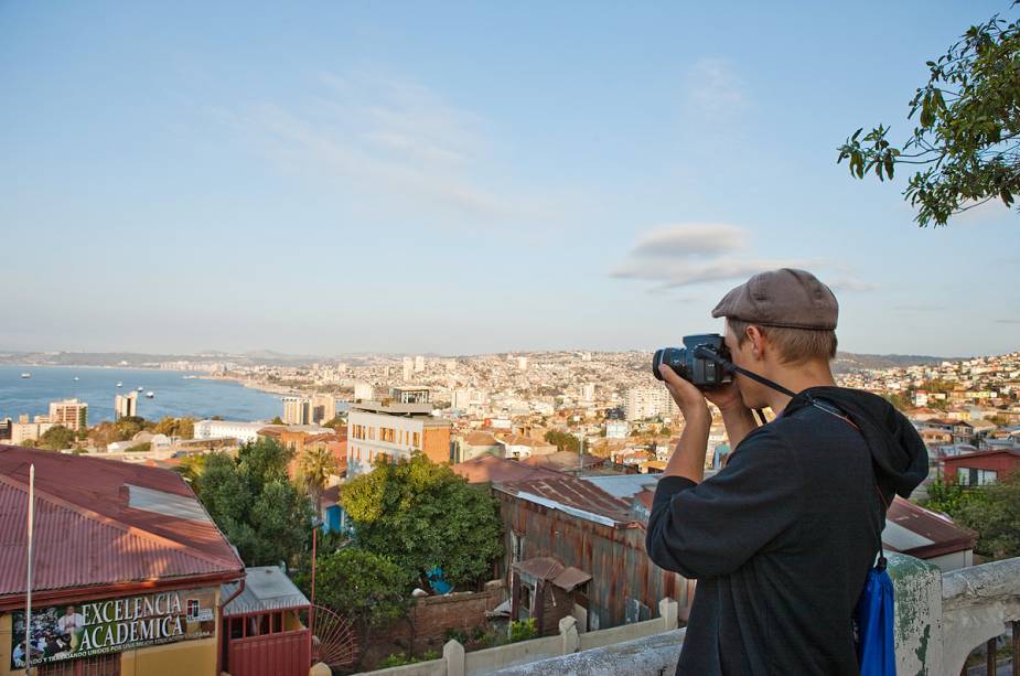 Turistas aproveitam a vista do Paseo 21 de Mayo para fotografar a cidade de Valparaíso de cima - há várias barracas de artesanato para turistas na rua estreita