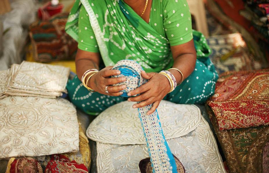 Mulher vende seda no mercado em Delhi, Índia