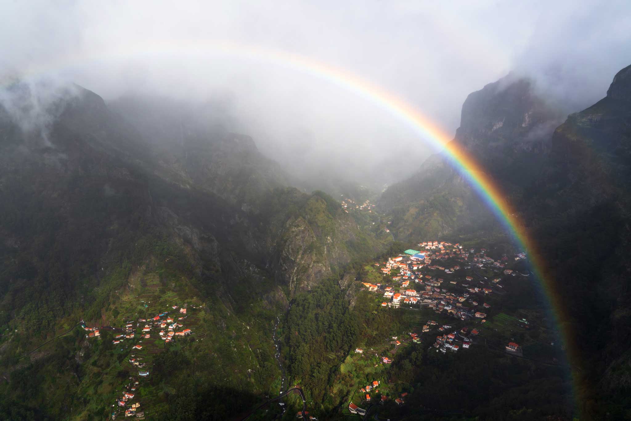 Um arco-íris em um vale de montanhas das freiras na Madeira