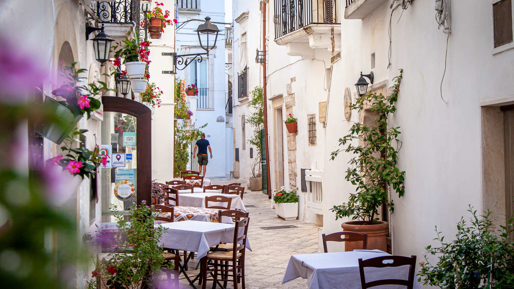 Um restaurante ao ar livre nas ruas brancas de Locorotondo Puglia