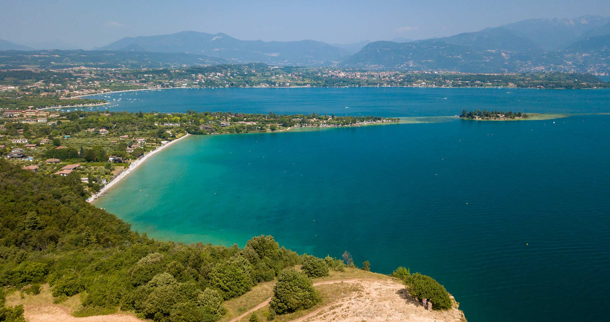 Lago Garda visto de cima de uma colina com vista para uma praia e ilhas
